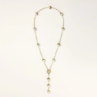 Gold-plated lariat necklace with baroque pearls and textured caps on cream background, showing adjustable Y-shaped design.