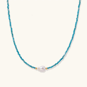 Delicate gold vermeil necklace with teal apatite beads and freshwater pearl on white background.