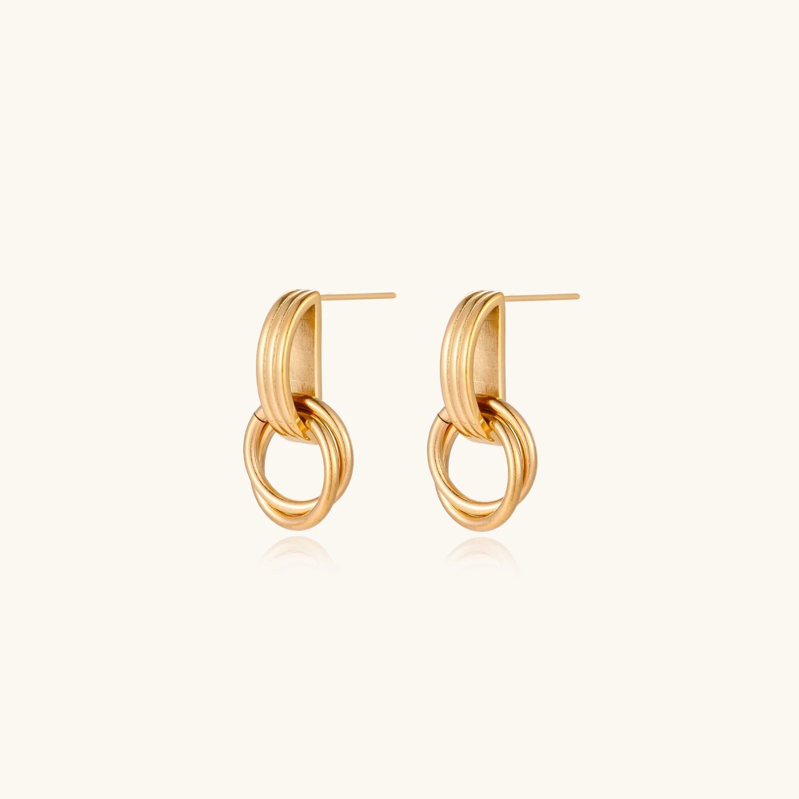 Gold stud earrings with vertical ridged bar connecting to triple interlocking circular rings on white background